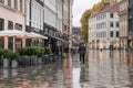 Copenhagen - October 22, 2016: A woman passing by the Amargertorv square during a light rain.