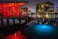 Copenhagen `s canal at night with red and blue underwater neon lights and modern buildings by the water reflecting on a calm sea Royalty Free Stock Photo