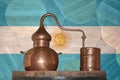 Copper alambik on the background of the national flag of Argentina. Winemaking. Royalty Free Stock Photo