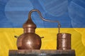 Copper alambik on the background of the national flag of Ukraine. Winemaking and distillery.