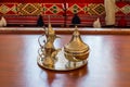 Copper antique Arabian tea pot and cups and tray on the table with background of Arabian traditional sofa Royalty Free Stock Photo