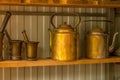 Copper antique teapots and mortars are on the shelf