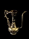 Copper antique vase on a black background. Bronze dishes with patterns and ornaments. Golden carafe for decoration