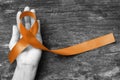 Copper Awareness Ribbon symbolic color for Herpes Simplex Virus (HSV 1 and HSV 2) on helping hand support Royalty Free Stock Photo