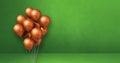 Copper balloons bunch on a green wall background. Horizontal banner Royalty Free Stock Photo