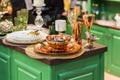 Copper and bronze color tableware. In the green kitchen, a set of glass beautiful modern dishes