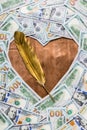 Copper bronze heart shape and gold quill pen in center of money