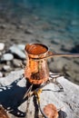 Copper Cezve for coffee in autumn lake camping in the mountains