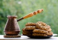 Copper Cezve of coffee in the open air, a plate of cookies