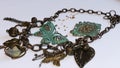 Copper chain with decorative green butterflies, leaves, flowers, hearts and beads on grey