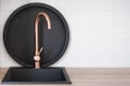 Copper faucet over empty sink against black breakfast tray Royalty Free Stock Photo