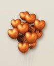 Copper heart shape air balloons group on a beige background