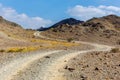 Copper Hike trail, winding gravel dirt road through Wadi Ghargur riverbed and rocky limestone Hajar Mountains in Hatta, UAE Royalty Free Stock Photo