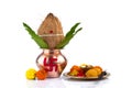 Copper Kalash with coconut and mango leaf and pooja thali with diya, kumkum and sweets with floral decoration on a white Royalty Free Stock Photo