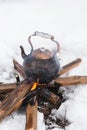 Copper kettle over an open fire in winter