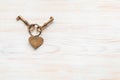 Bronze color keys and heart together lying on wooden board. Space for text Royalty Free Stock Photo