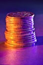 A stack of copper coins with colored lighting close-up Royalty Free Stock Photo