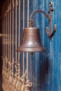 Copper old vintage bell, doorbell, rope on a wooden blue aged wall. Concept decor element in interior of deck, cabin of ship, Royalty Free Stock Photo