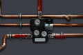 Copper pipes and thermoregulator with valves on a grey wall Royalty Free Stock Photo