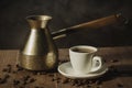 Copper pot and hot coffee cup/copper pot and hot coffee cup on a wooden table with dark background Royalty Free Stock Photo