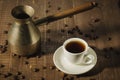 copper pot, hot cup and coffee beans/copper pot, hot cup and coffee beans on a wooden background. Top view Royalty Free Stock Photo