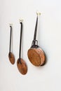 Copper pots and kitchen utinsils hanging on a white painted wall