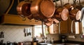 Copper pots and pans hang from a kitchen rack, reflecting warm light. Their smooth, Royalty Free Stock Photo
