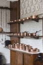 Copper pots, pans, saucepans and utensils in an old-fashioned kitchen