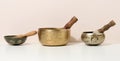 Copper singing bowl and wooden clapper on a white table. Musical instrument for meditation, relaxation, various medical practices