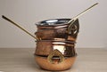 copper and stainless serving dishes (indian handi, karahi pots, spoon, bowl with handles) stacked