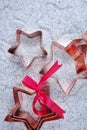 Copper star-shaped cookies cutter for Christmas on shiny mirrored background