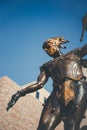 Copper statue of a knight with a clear blue sky in the background