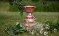 Copper still with herbs in a grassy field Royalty Free Stock Photo