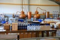 Copper stills and bottles in distillery