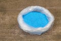 Copper Sulphate Crystals in a bag, Wooden background Royalty Free Stock Photo