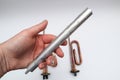 Copper Tubular Heating Element for Electric Water Heater, Electric Water Boiler. Hand holding New cooper heater with magnesium