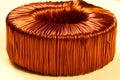 Toroidal transformer with a winding of copper wire of bright color.