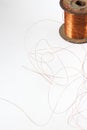 Copper wire spool. Red insulated wire wound up on plastic spindle. End of wire is stripped showing bare copper. Isolated Royalty Free Stock Photo