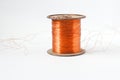 Copper wire spool. Red insulated wire wound up on plastic spindle. End of wire is stripped showing bare copper. Isolated Royalty Free Stock Photo