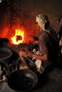 Coppersmith at work with fire at Tambat Ali, Copper market, Pune, India