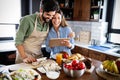 Copule in home kitchen looking at recipe on the web and cooking Royalty Free Stock Photo