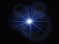 A bright white light source radiates multiple sharp, blue beams against a deep black background, creating a star-like effect. Royalty Free Stock Photo