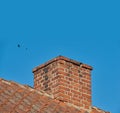 Copy space with a chimney on the roof of a building against a clear blue sky background. Exterior design of a chute Royalty Free Stock Photo