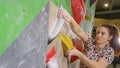 CLOSE UP: Athletic woman climbs along the wall at a rock-climbing facility. Royalty Free Stock Photo