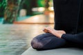 Copy space. Close up of leg in lotus pose. Girl meditating or praying. Young woman practicing yoga alone on wooden deck Royalty Free Stock Photo