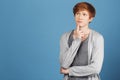 Copy space. Colorful blue background. Portrait of young beautiful male student in casual outfit holding finger near Royalty Free Stock Photo