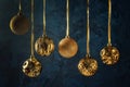 Copy space on a dark blue background with decorative putty textures. Six golden christmas balls hanging on ribbons