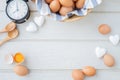 Copy space frame for text on white kitchen table with fresh raw eggs, yellow yolk eggs, white heart shape sign and classic vintage Royalty Free Stock Photo