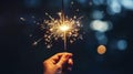 copy space, Hand holding burning Sparkler blast on a black bokeh background at night, holiday celebration event party. Background