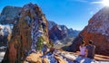 COPY SPACE: Young couple sits atop Angel\'s Landing and observes the canyon